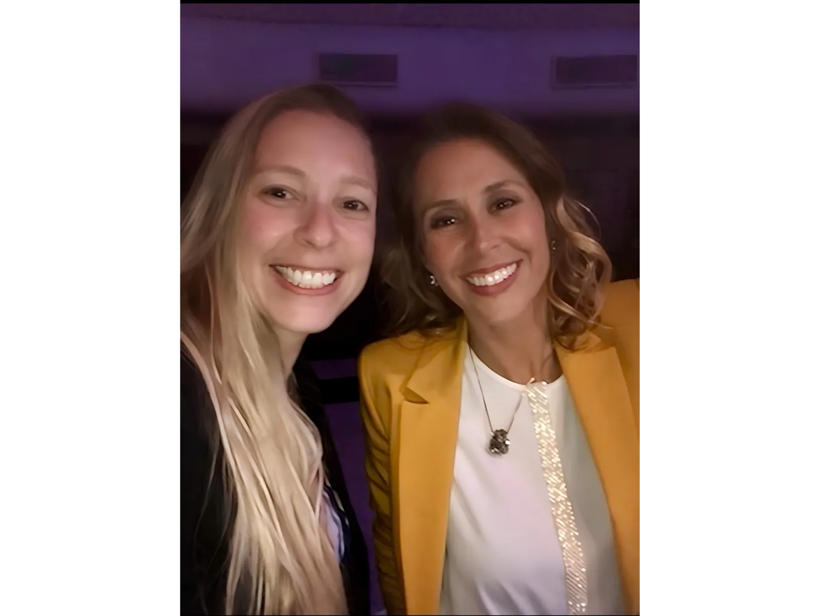 Pilar Moretzsohn e outra participante sorriem em uma selfie durante um evento.